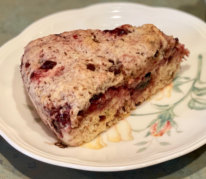 Photo of a cherry chocolate jammy scone on a plate.